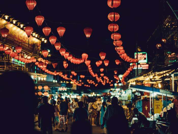 An image of a night market in vietnam with several street food stalls and people