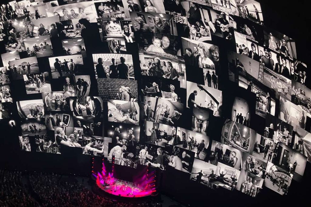 An image of Phish performing inside Sphere with lots of pictures of them over the years displayed as poloaroid images