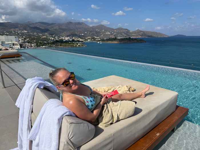 Rachel relaxing on a daybed beside the rooftop pool at InterContinental Crete in Agios Nikolaos, Greece.